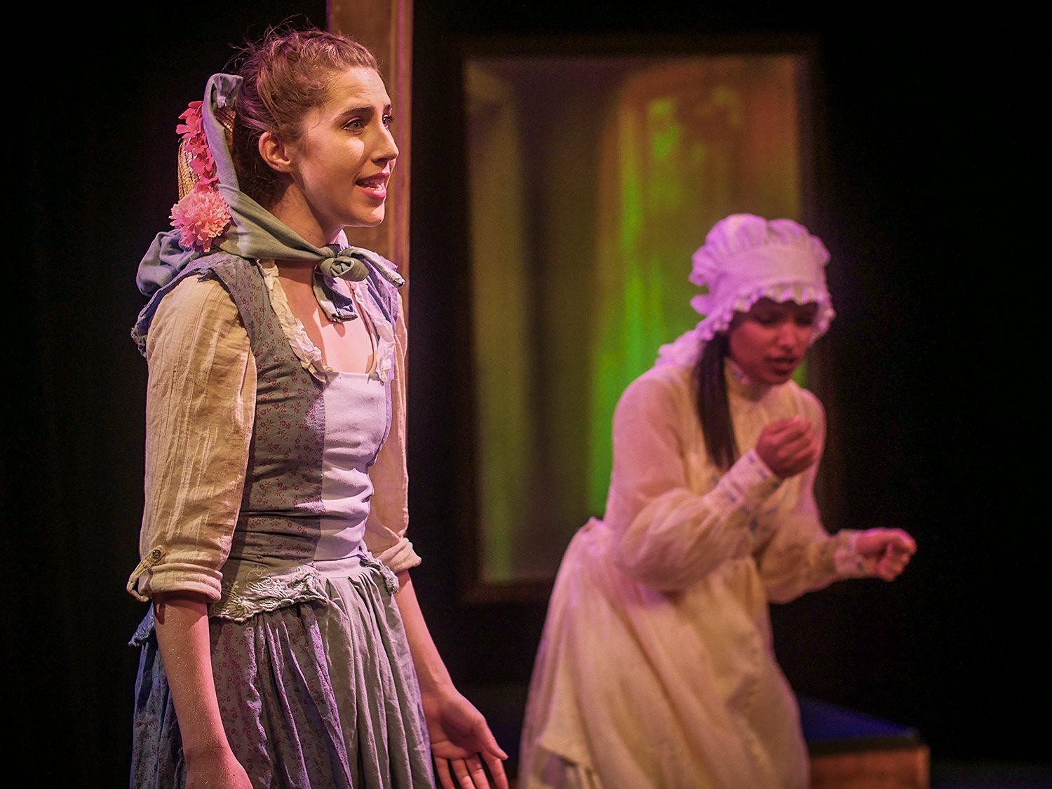Kat looks plaintively into the distance, wearing a blue frock and bonnett